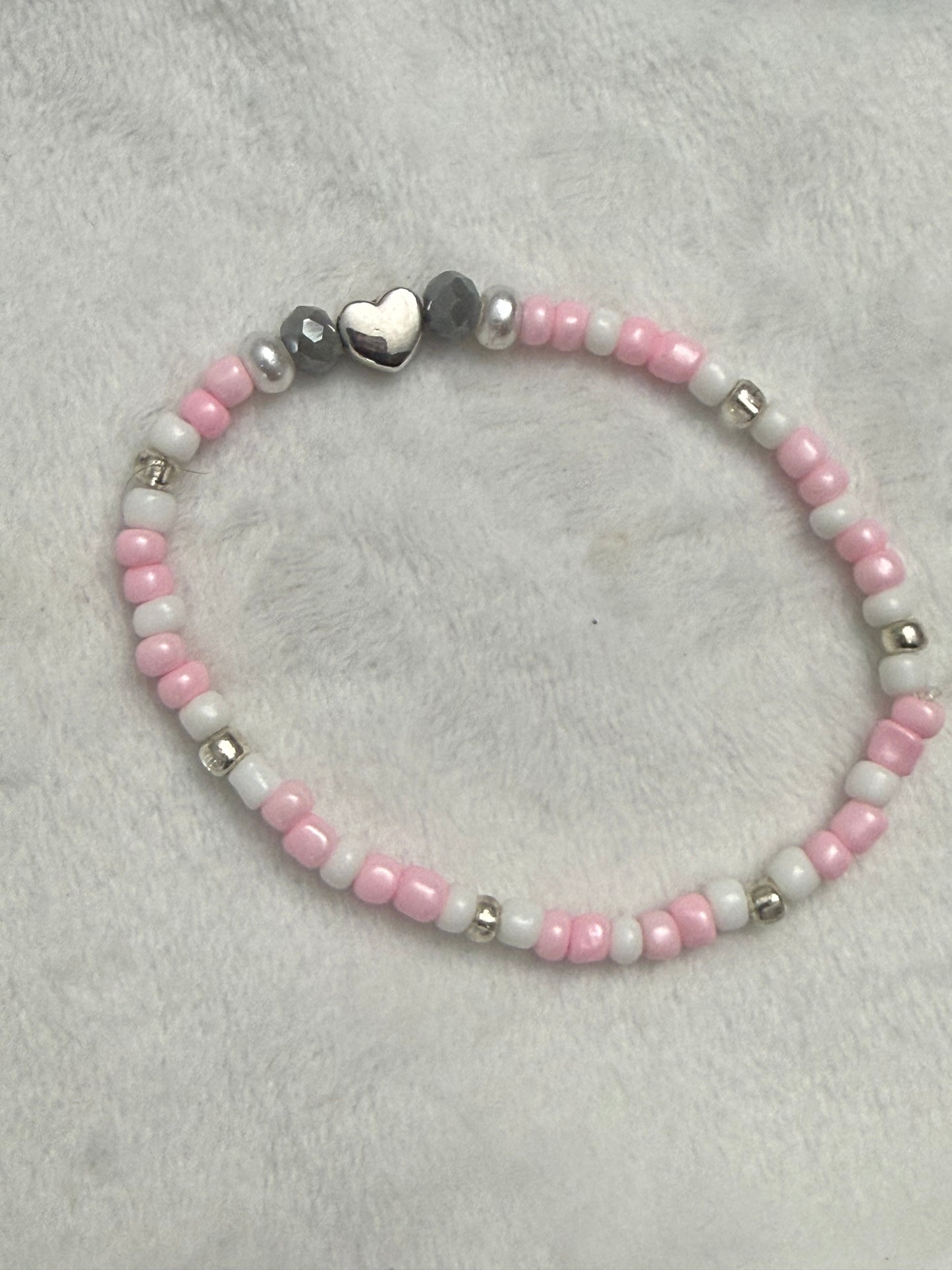 Pink seed bead bracelet with a silver charm
